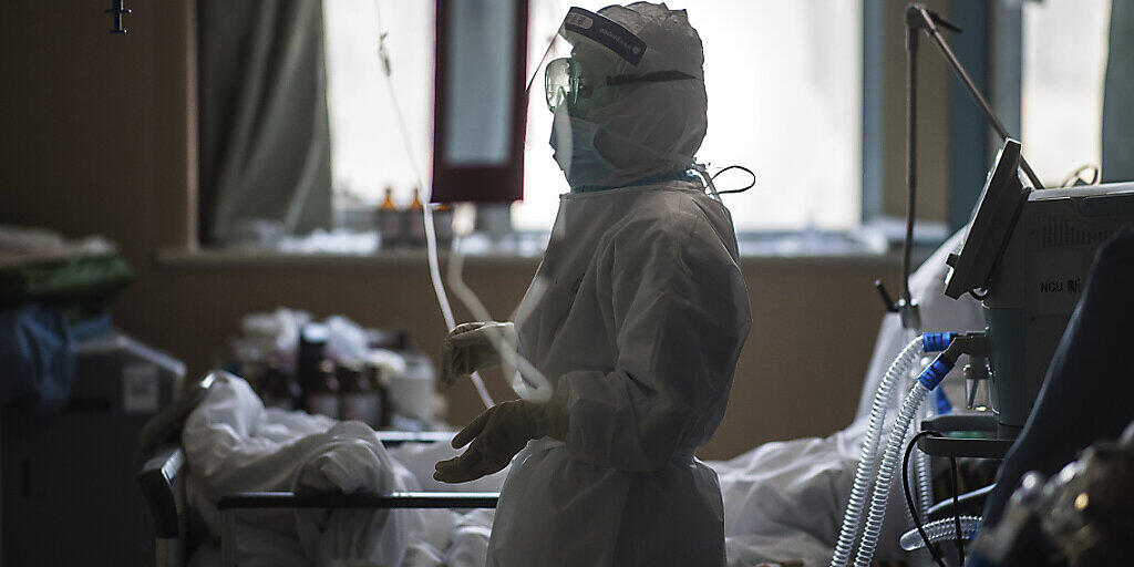 Eine Krankenschwester in Schutzkleidung betreut Patienten im Zentrum des Coronavirus-Ausbruchs in der Stadt Wuhan. (Foto: Xiao Yijiu/AP Keystone-SDA)