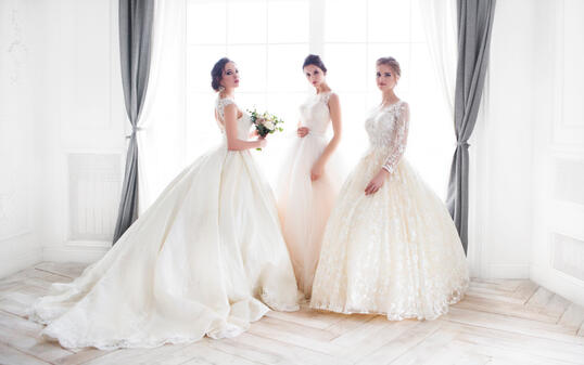 Young woman with bouquets wearing wedding dresses