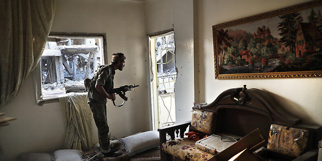 Ein Kämpfer des SDF bringt sich in einer zerstörten Wohnung an der Frontlinie in der umkämpfen Stadt al-Rakka in Stellung gegen die Kämpfer des IS. (Archivbild)