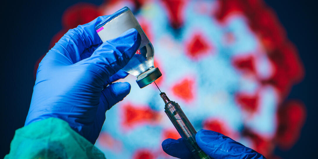 Coronavirus Covid-19 Protection and Vaccine. Doctor drawing up solution from vaccine bottle and filling syringe injection for patient vaccination in medical clinic, Coronavirus in background