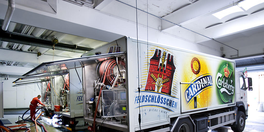Ein Mitarbeiter der Brauerei Feldschlösschen in Rheinfelden füllt einen Tankwagen mit Bier: Die Brauerei, die zur dänischen Carlsberg-Gruppe gehört, kommt in der Schweiz auf einen Marktanteil von 43 Prozent. Ein Mitarbeiter der Brauerei Feldschlösschen in Rheinfelden füllt einen Tankwagen mit Bier: Die Brauerei, die zur dänischen Carlsberg-Gruppe gehört, kommt in der Schweiz auf einen Marktanteil von 43 Prozent.