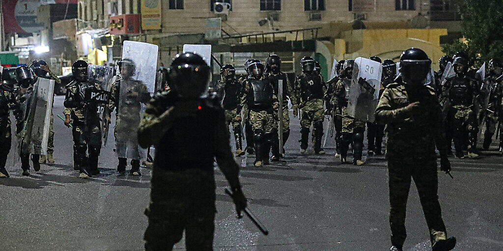 Polizisten versuchen während eines Protests in Basra Demonstranten daran zu verhindern, ein Regionalbüro des Parlaments zu stürmen. Foto: Nabil Al-Jurani/AP/dpa