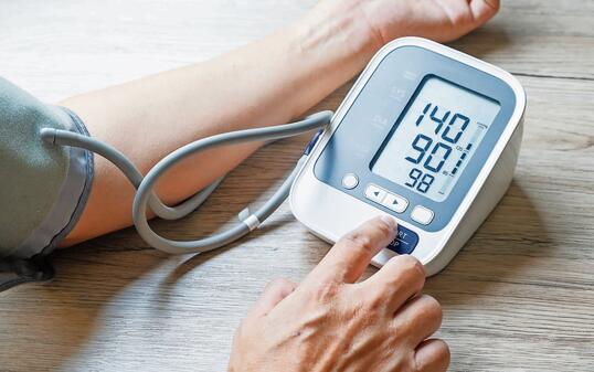 Man checks blood pressure monitor and heart rate monitor with digital pressure gauge. Health care and Medical concept.