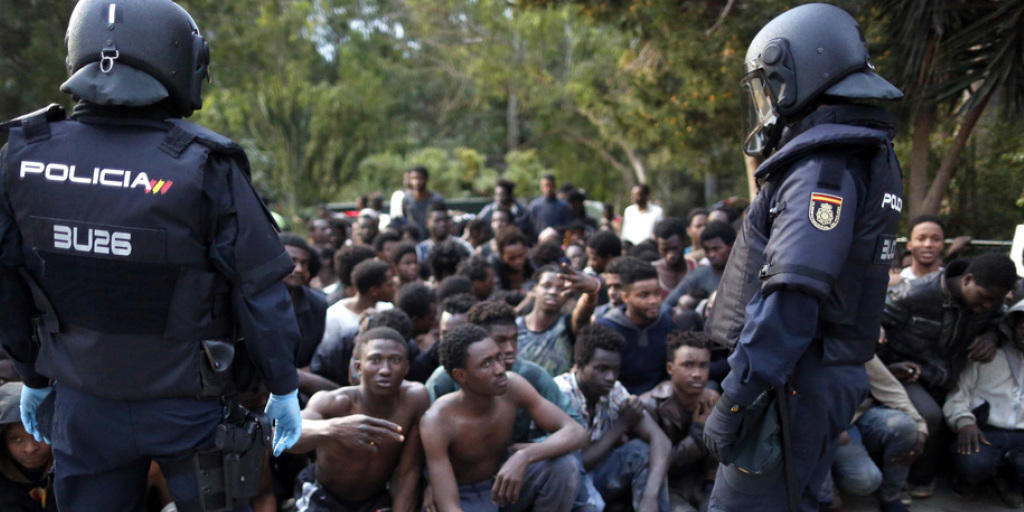 Von der Polizei bewachte Flüchtlinge nach der Überwindung des Grenzzauns am Freitag in Ceuta.