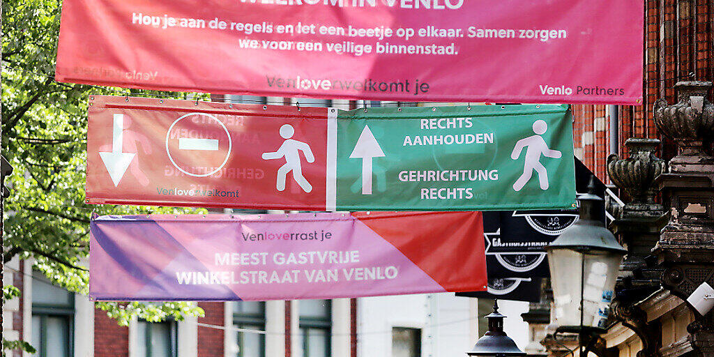 ARCHIV - Banner informieren in der Innenstadt von Venlo über die Einschränkungen. Foto: David Young/dpa
