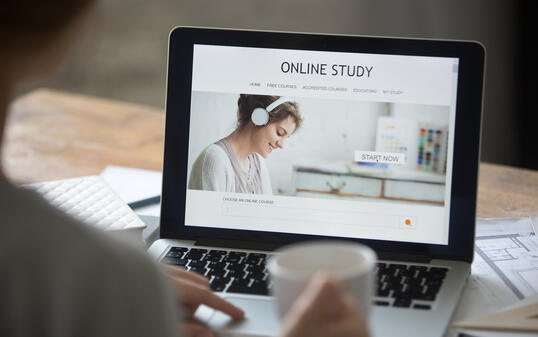 Open laptop on the desk, with online study on screen