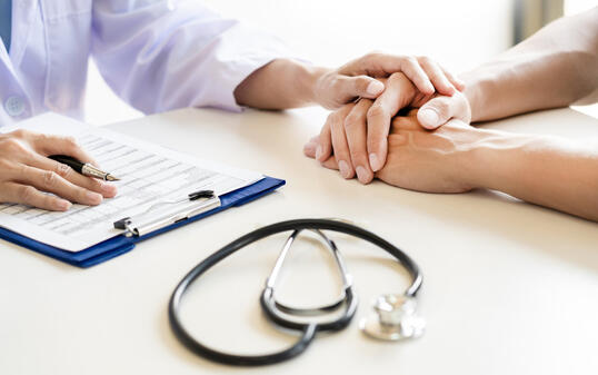 Midsection Of Doctor Consoling Patient In Hospital