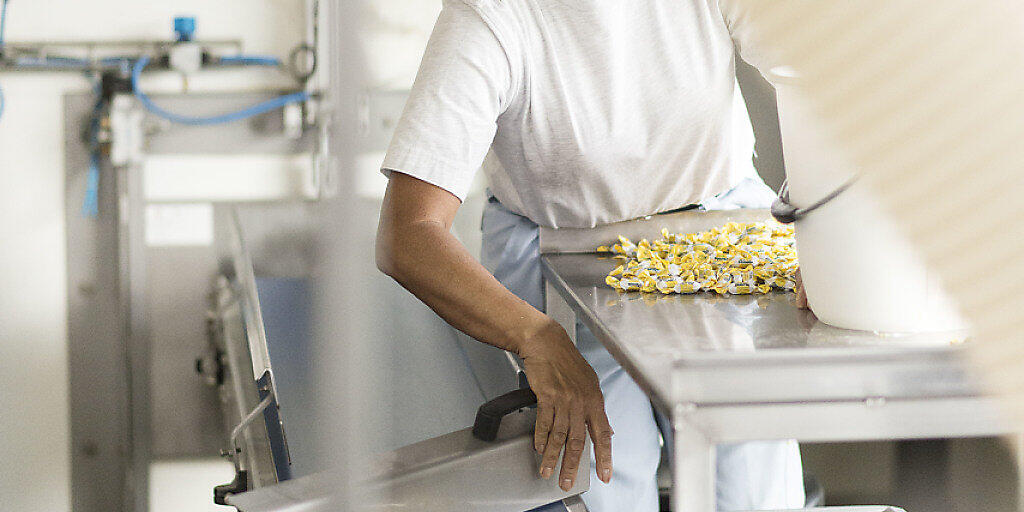 Eine Mitarbeiterin sortiert in der Ricola-Fabrik in Laufen die "Däfeli" des Baselbieter Süsswaren-Produzenten (Archivbild).