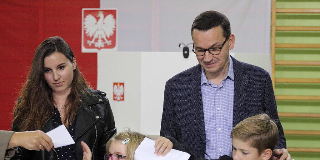 Polens Ministerpräsident Mateusz Morawiecki mit Familie am Sonntag bei der Stimmabgabe - die Regierungspartei Recht und Gerechtigkeit (PiS) von Morawiecki errang bei der Parlamentswahl ersten Prognosen zufolge einen klaren Sieg.