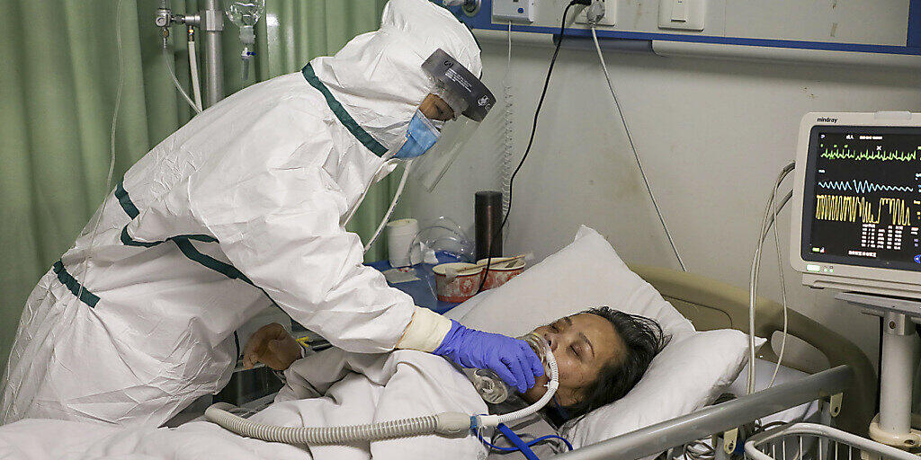 Eine Pflegefachfrau in einem Spital in der chinesischen Stadt Wuhan gibt einem am neuartigen Coronavirus erkrankten Patienten Wasser ein.