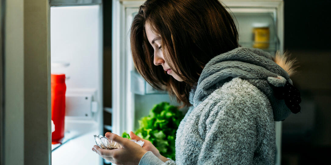 Young girl at night in front of a refrigerator Young girl at night in front of a refrigerator