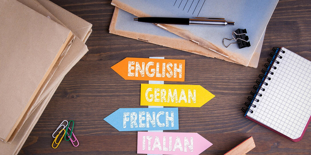 languages concept, English, Italian, German, French, Spanish. Paper signpost on a wooden desk