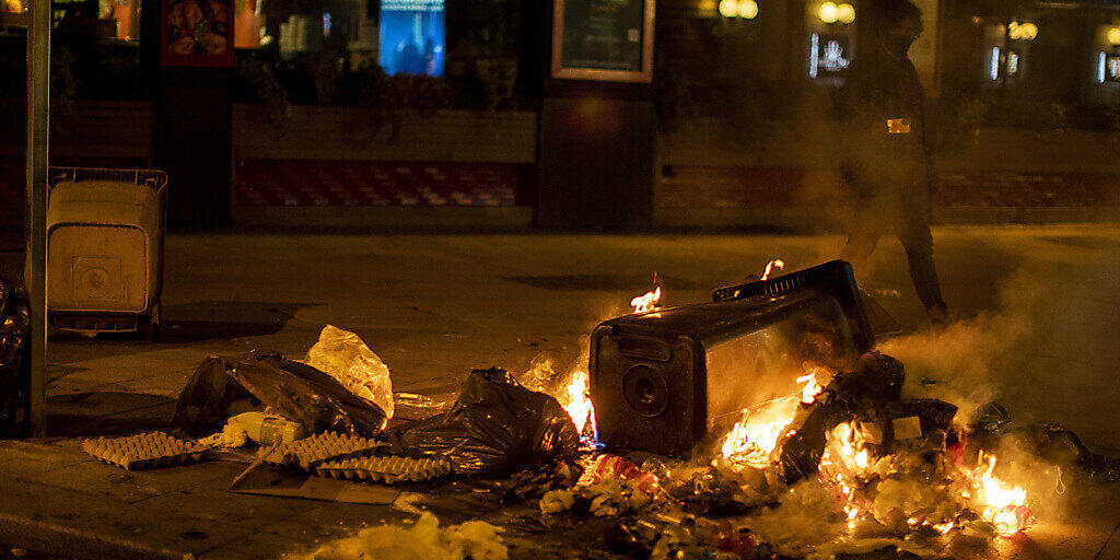 Ein Müllcontainer brennt in Madrid während eines Protests gegen die Ausgangssperre. Spanien ist eines der von der Corona-Krise am schwersten getroffenen Länder Westeuropas. Foto: Manu Fernandez/AP/dpa Ein Müllcontainer brennt in Madrid während eines Protests gegen die Ausgangssperre. Spanien ist eines der von der Corona-Krise am schwersten getroffenen Länder Westeuropas. Foto: Manu Fernandez/AP/dpa