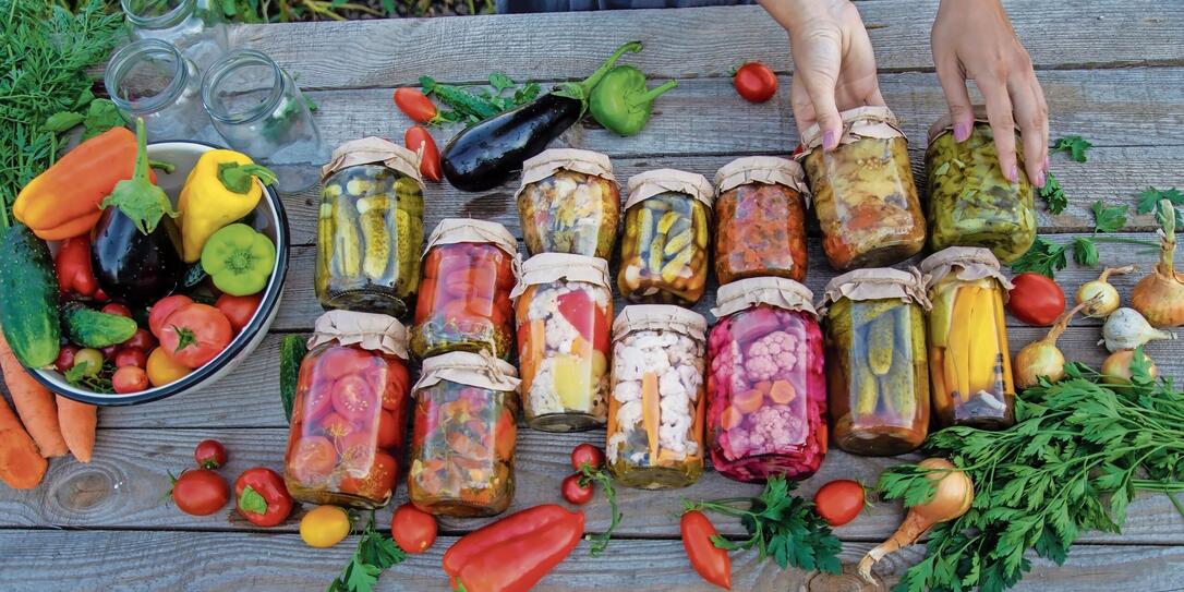 Woman canning vegetables in jars on the background of nature. preparations for the winter Woman canning vegetables in jars on the background of nature. preparations for the winter