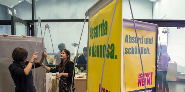 Helferinnen hängen Plakate gegen die Ecopop Initiative in Bern auf