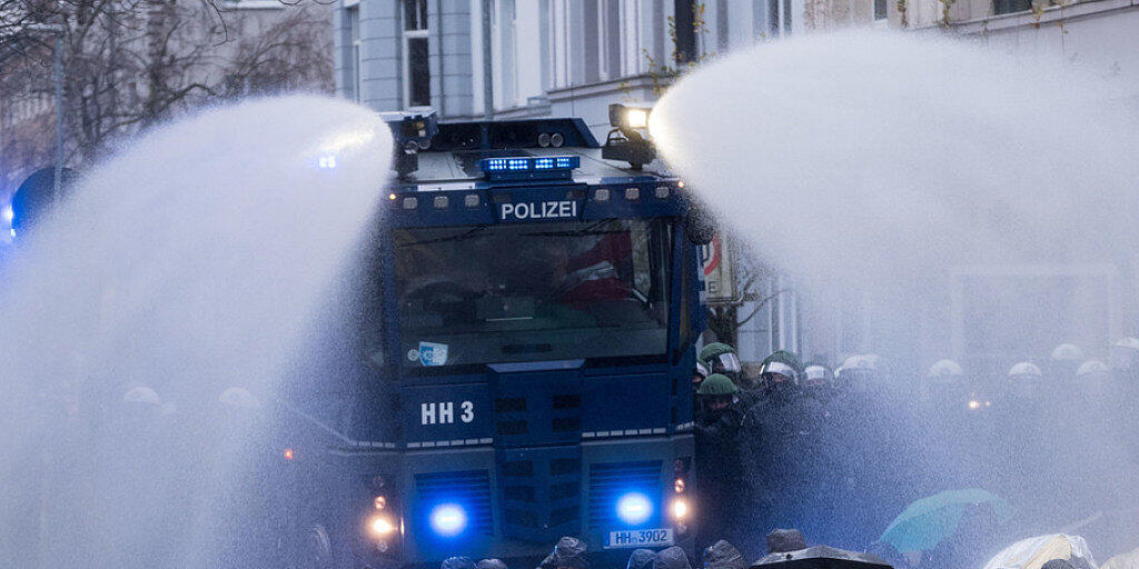Die Polizei räumt am Samstag in Hannover mit einem Wasserwerfer eine von AfD-Gegnern besetzte Strasse.