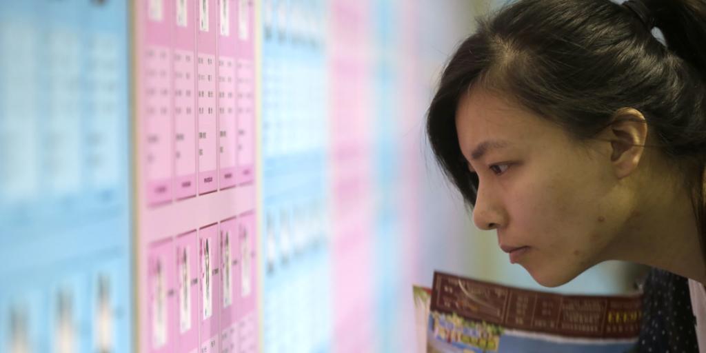 Eine junge Chinesin blickt auf den Aushang einer Partnerbörse: Der "Tag der Singles" wurde in den Neunziger Jahren von Studenten als Antwort auf den Valentinstag ins Leben gerufen (Archiv).