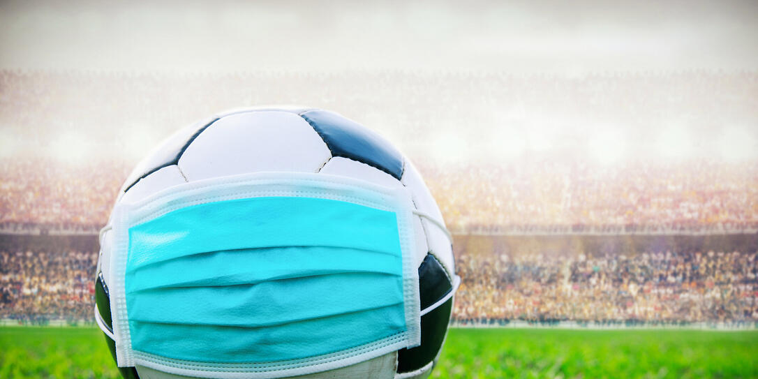 soccer ball with medical mask in the stadium. All event of soccer pause break. covid-19 spreading outbreak