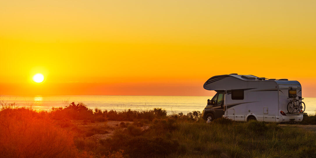 Caravan on sea at sunrise.