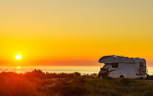Caravan on sea at sunrise.
