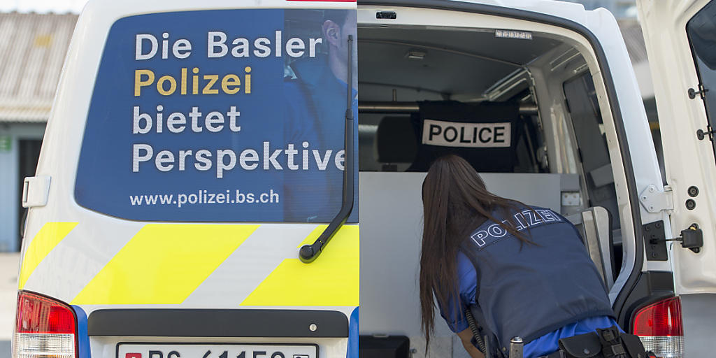 Eine baselstädtische Polizeiangehörige belädt ein Dienstfahrzeug. (Symbolbild)