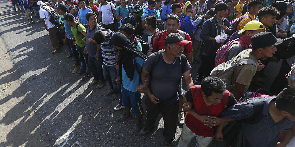 Von mexikanischen Nationalgardisten aufgehaltene Migranten bilden in der Nähe der mexikanisch-guatemaltekischen Grenze eine Menschenkette.