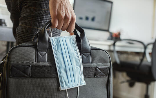 man with a briefcase and a surgical mask