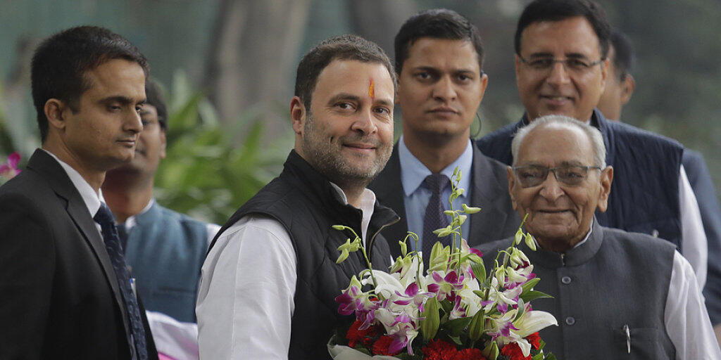 Rahul Gandhi (Mitte) mit Blumenstrauss - er führt künftig  Indiens Kongresspartei an.