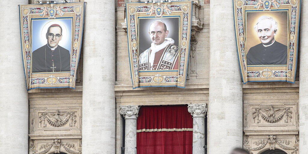 Während der Heiligsprechung von Erzbischof Oscar Romero (l.), Paul VI. (M.) und eines weiteren Seligen prangen deren Grossporträts an der Fassade des Petersdoms. Während der Heiligsprechung von Erzbischof Oscar Romero (l.), Paul VI. (M.) und eines weiteren Seligen prangen deren Grossporträts an der Fassade des Petersdoms.