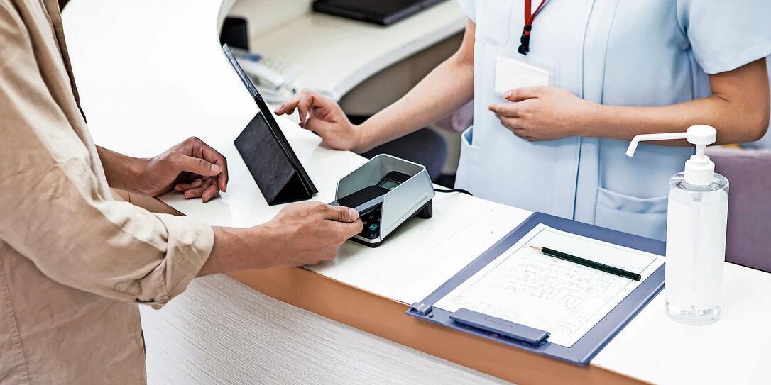 A man paying at a hospital using a smartphone A man paying at a hospital using a smartphone