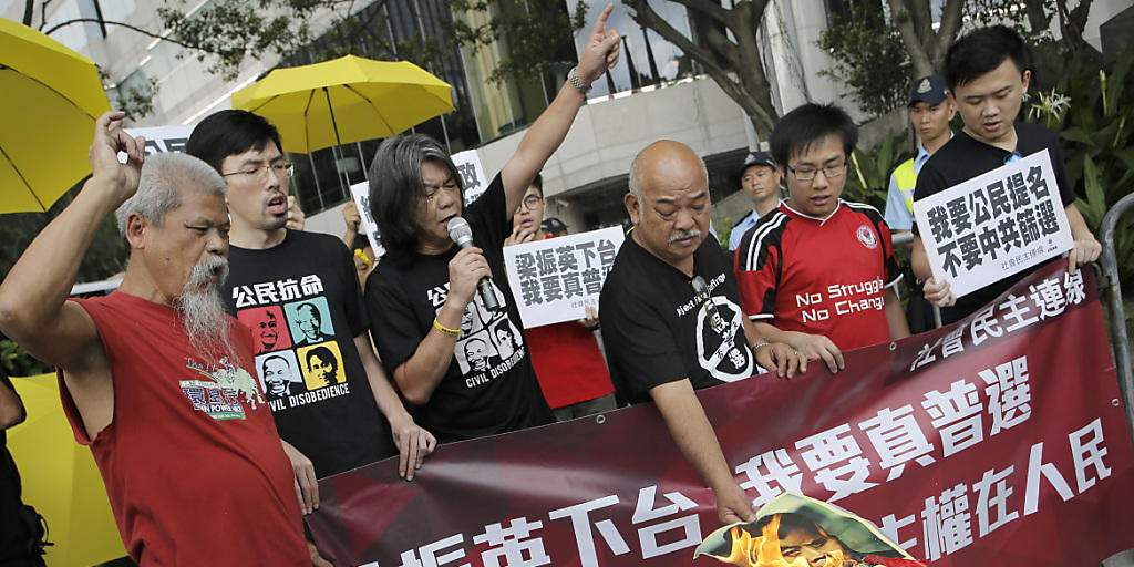 Demonsration für mehr Demokratie in Hongkong. Ein Demonstrant verbrennt ein Bild vom Exekutive-Chef Leung Chun-Ying.