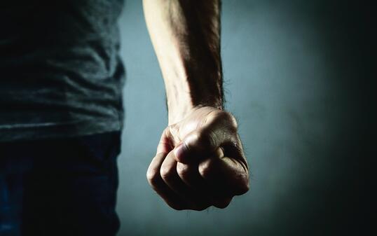 Caucasian angry and aggressive man threatening with fist.