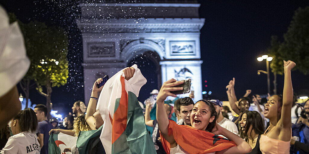 Ausgelassener Jubel: Algerische Fussballfans feiern vor dem Arc de Triomphe in Paris