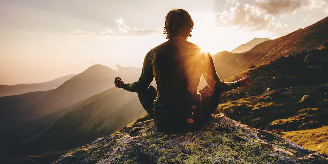 Man meditating yoga at sunset mountains Travel Lifestyle relaxation emotional concept adventure summer vacations outdoor harmony with nature