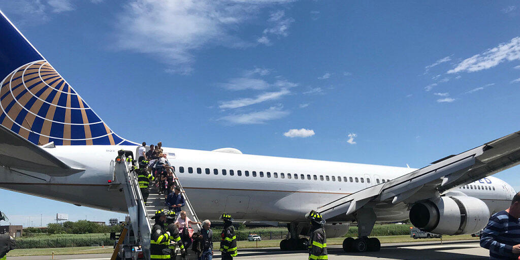 Rettungspersonal hilft bei der Evakuierung eines Flugzeugs der United Airlines, das auf dem Flughafen Newark bei New York teilweise von der Landebahn abgekommen ist.  (Caroline Craddock via AP)
