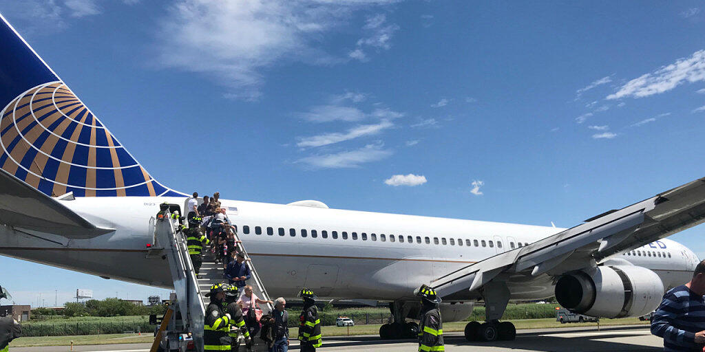 Rettungspersonal hilft bei der Evakuierung eines Flugzeugs der United Airlines, das auf dem Flughafen Newark bei New York teilweise von der Landebahn abgekommen ist. (Caroline Craddock via AP)
