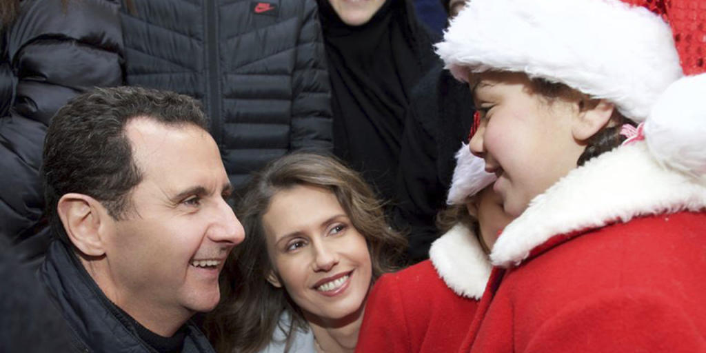 Der syrische Präsident Baschar al-Assad (links) und seine Ehefrau Asma (Mitte) begrüssen als Weihnachtsmänner verkleidete christliche Waisen in Sednaja nördlich von Damaskus (in einer Aufnahme vom Sonntag, wie sie auf der Facebook-Seite des syrischen Präsidialamtes erschien).