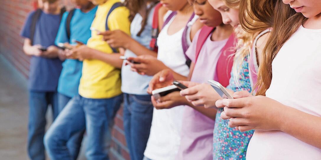 Cute pupils using mobile phone