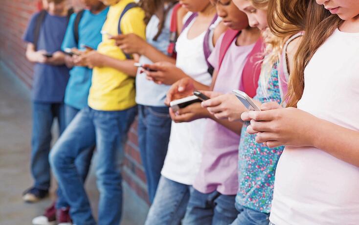 Cute pupils using mobile phone