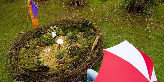 Person mit Regenschirm vor einem riesigen Osternest (Archivbild) Person mit Regenschirm vor einem riesigen Osternest (Archivbild)