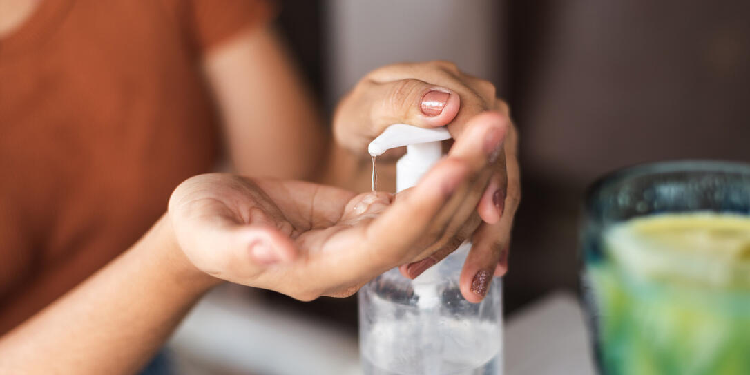 Young woman sanitizing her hands before snack at a restaurant