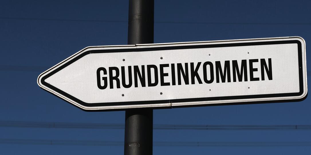 Ein Wegweiser mit dem Wort Grundeinkommen