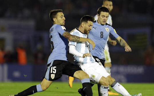Lionel Messi wird von seinen uruguayischen Bewachern bedrängt