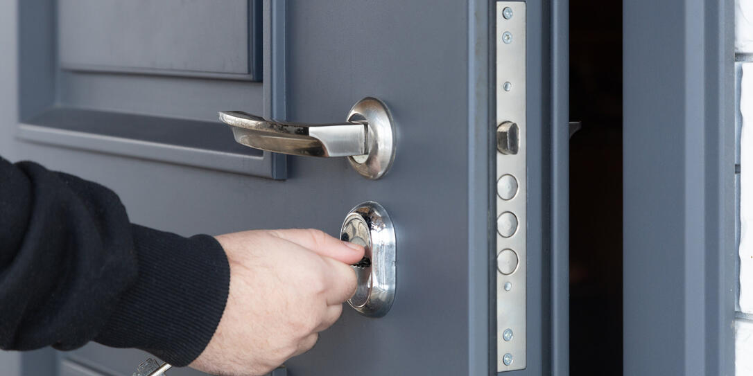 Man opens the lock of the front door of a private house.
