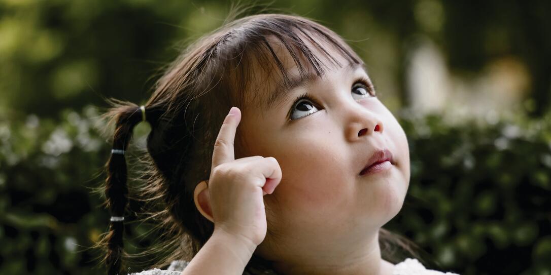 Beautiful kid playing Thinker with serious Beautiful kid playing Thinker with serious