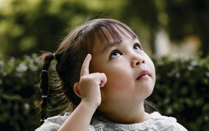 Beautiful kid playing Thinker with serious