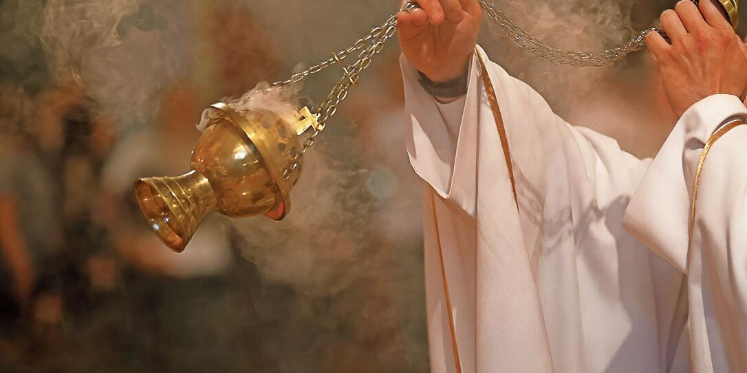 Priest incenses the altar with incense during Holy Mass