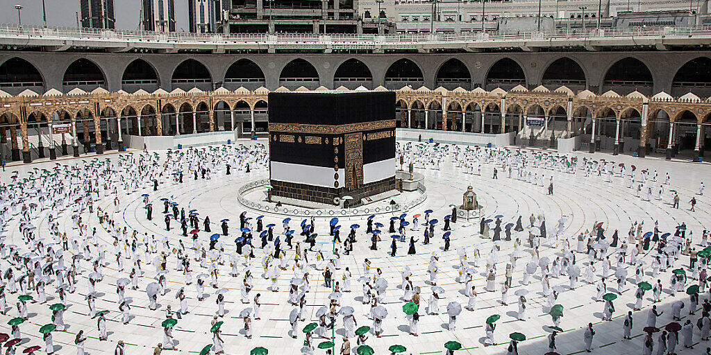 HANDOUT - Hunderte von muslimischen Pilgern umkreisen die Kaaba, das kubische Gebäude der Großen Moschee, während sie als Schutz vor der Ansteckung mit dem Coronavirus vor der Hadsch-Pilgerfahrt Abstand beibehalten. Foto: Saudi Ministry of Media/dpa - ACHTUNG: Nur zur redaktionellen Verwendung und nur mit vollständiger Nennung des vorstehenden Credits HANDOUT - Hunderte von muslimischen Pilgern umkreisen die Kaaba, das kubische Gebäude der Großen Moschee, während sie als Schutz vor der Ansteckung mit dem Coronavirus vor der Hadsch-Pilgerfahrt Abstand beibehalten. Foto: Saudi Ministry of Media/dpa - ACHTUNG: Nur zur redaktionellen Verwendung und nur mit vollständiger Nennung des vorstehenden Credits
