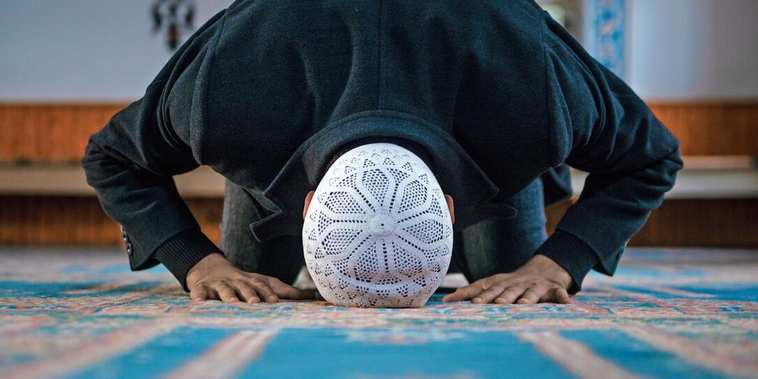 Close-up shot of a Muslim young man worshiping in a mosque