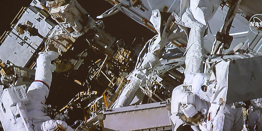 David Saint-Jacques (r,) und Anne McClain hangeln sich an der Aussenwand der ISS entlang.
